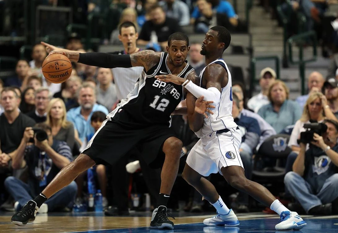 LaMarcus Aldridge #12 of the San Antonio Spurs dribbles the ball against Harrison Barnes #40 of the Dallas Mavericks in the second half at American Airlines Center on November 14, 2017 in Dallas, Texas. (Ronald Martinez/Getty Images/AFP)