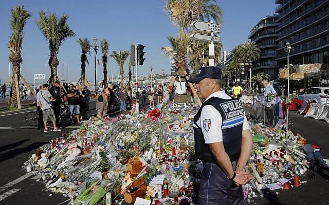 A policeman stands guard by floral tributes following the Nice truck attack in which 86 were killed and 400 injured (AP)