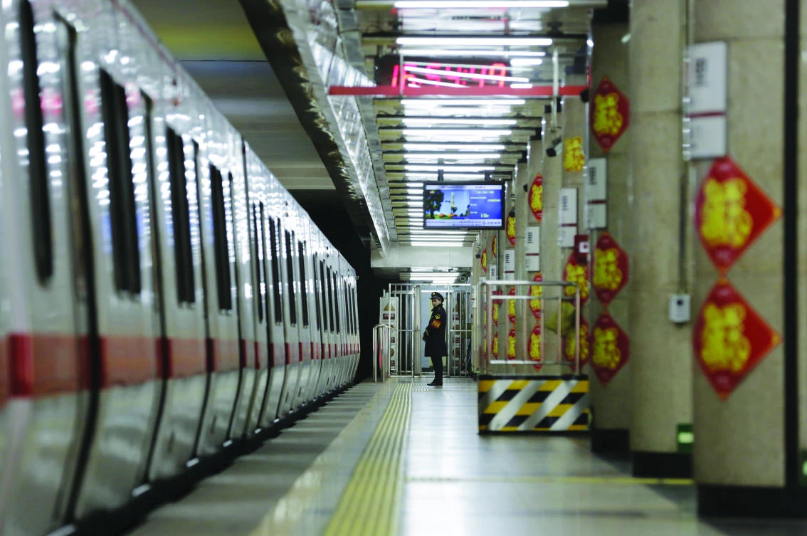 A member of security personnel stands on duty on an empty train
platform inside a station on the Subway Line Number 1 in Beijing,
China. (Reuters