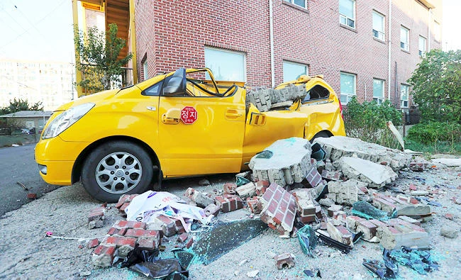 A car damaged by falling bricks after a 5.4-magnitude earthquake is seen in the southeastern port city of Pohang on Wednesday. (AFP)