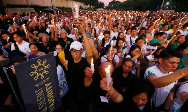 Civil society groups raise their candles as they recite prayers during a rally led by the Roman Catholic church, on Sunday, Nov. 5, 2017 in suburban Quezon city northeast of Manila, Philippines. Philippine family planning law to provide free hormonal contraceptives is finally going ahead, health officials said on Thursday, Nov.16, 2017 (AP)