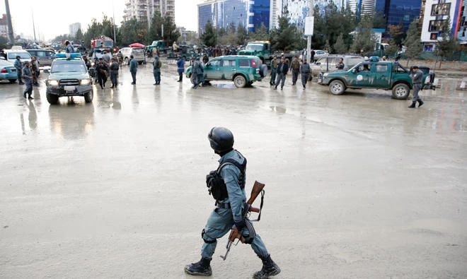 Afghan policemen stand guard after a suicide bomb attack in Kabul, on Thursday. (Reuters)