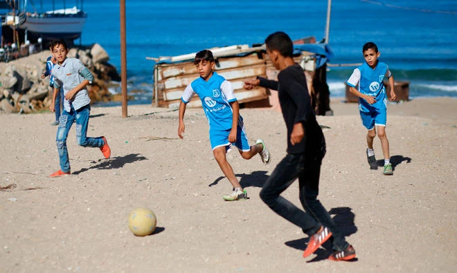 Palestinian boys play football in Gaza City. Israel prosecutes 500-700 children each year in military courts that lack fundamental fair-trial rights and protections. (File/AFP)
