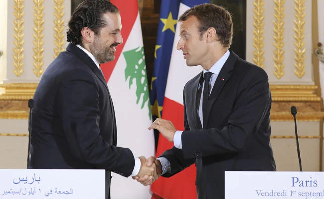 In this Sept. 1 2017 file photo, French President Emmanuel Macron, right, shakes hands with Lebanese Prime Minister Saad Hariri during a joint press conference at the Elysee Palace in Paris. Hariri has accepted an invitation to come to France after his surprise resignation nearly two weeks ago. (Ludovic Marin, Pool via AP, File)