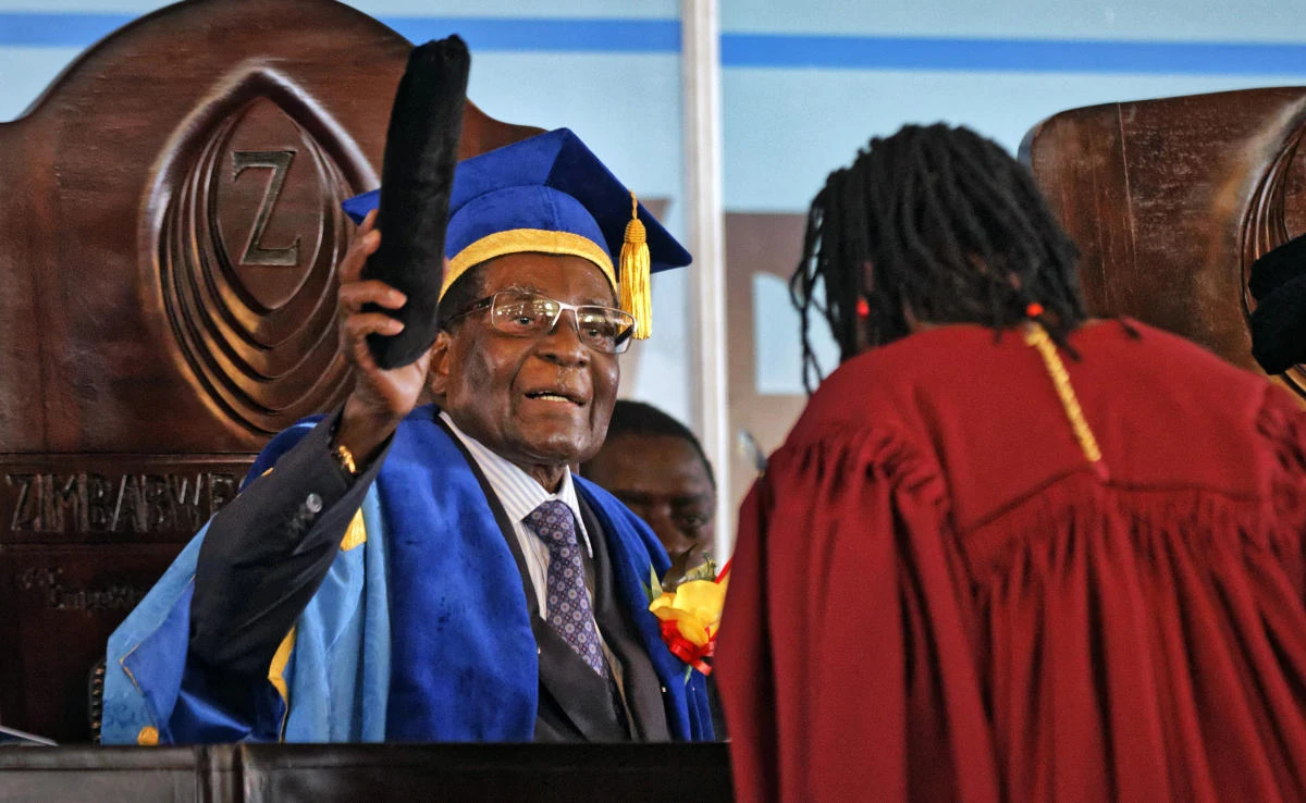 Zimbabwe’s President Robert Mugabe, left, confers awards for the students with the leading theses, as he presides over a graduation ceremony at Zimbabwe Open University on the outskirts of Harare, Zimbabwe on Friday, November 17, 2017. (AP)