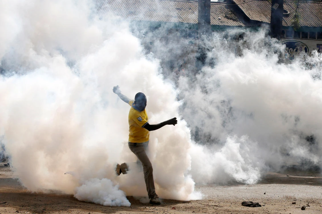 A man makes his way through rising tear gas fired by riot police officers to disperse supporters of Kenyan opposition leader Raila Odinga in Nairobi, on Friday. (Reuters)