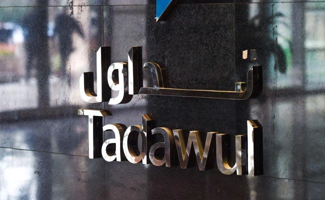 This file photo taken on April 04, 2017 shows the sign showing the name of the Saudi Stock Exchange (Tadawul) outside the exchange building. Saudi Energy Minister Khalid Al-Falih has assured that the ongoing anti-corruption investigations are linked to a just few individuals and will not hinder investments in the kingdom. (AFP / POOL / FAYEZ NURELDINE)