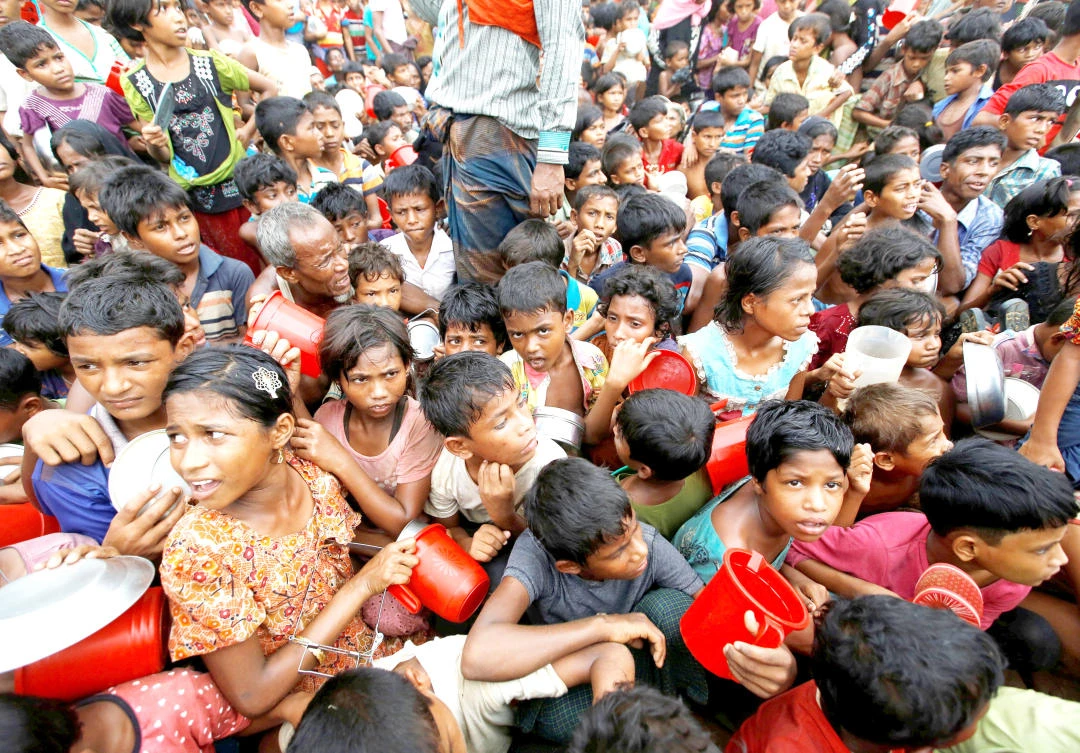 Rohingya refugee children wait to receive food outside the distribution center at Palong Khali refugee camp near Cox’s Bazar, Bangladesh, on Friday. (Reuters)