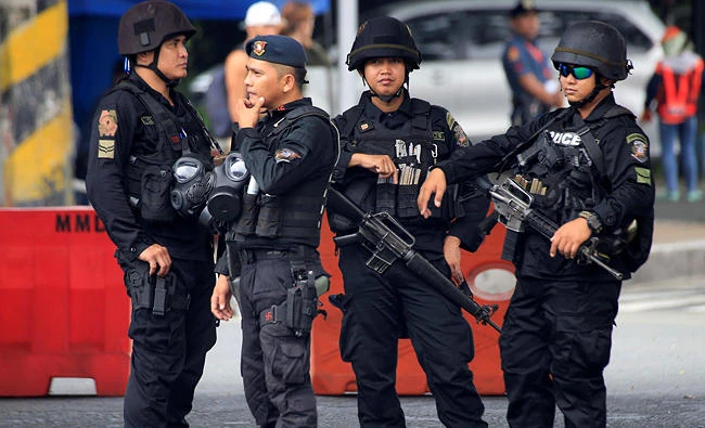 Members of the Philippine National Police (PNP) stand guard to monitor protesters during a rally to denounce the visit of U.S. President Donald Trump, who is attending the 31st Association of Southeast Asian Nations (ASEAN) leaders summit in metro Manila, Philippines November 12, 2017. REUTERS/Romeo Ranoco