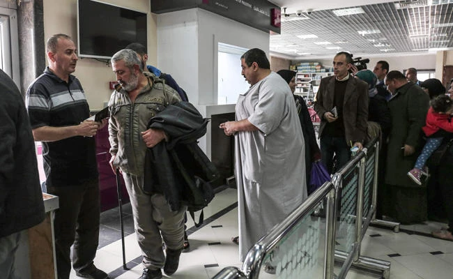 Palestinians queue to have their travel documents checked as they go through the Rafah border crossing with Egypt on Saturday. (AFP / SAID KHATIB