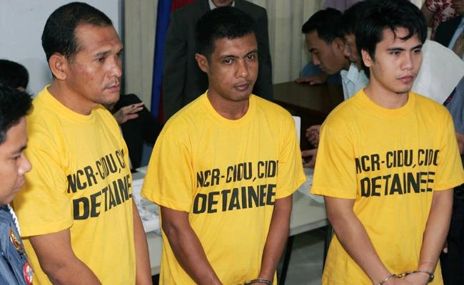 In this Nov. 19, 2007, file photo, left to right; from right, suspects Adnam Kusain, Ikram Indama and Caidar Aunal linked to the blast at the House of Representatives are lined up at the Department of Justice in Manila. Indama was convicted of multiple murders on Saturday, Nov. 18, 2017, while Kusain and Aundal were acquitted. (AP Photo/Bullit Marquez, FIle)
