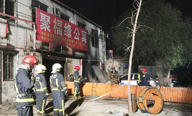 In this photo provided by China's Xinhua News Agency, firefighters work at the site of a fire in Daxing district of Beijing, capital of China, on Sunday. (Xinhua/Luo Xiaoguang)