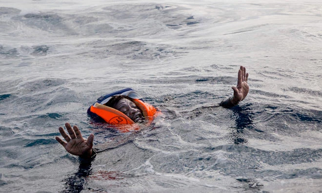A migrant tries to board a boat of the German NGO Sea-Watch in the Mediterranean Sea on November 6, 2017. Algeria's coast guard has picked up 286 illegal migrants heading across the Mediterranean to Europe by boat, the Defense Ministry said on Sunday, Nov. 19, 2017. (AFP / Alessio Paduano)