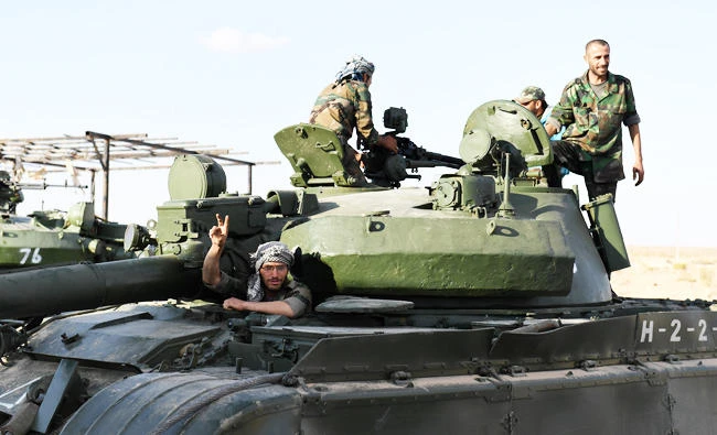 A member of the Syrian pro-regime forces flashes the victory gesture from the hatch of a tank before advancing towards rebel-held positions west of Aleppo, near Abu al-Zuhur military airport in the Idlib province countryside, in this November 11, 2017 photo. (AFP)