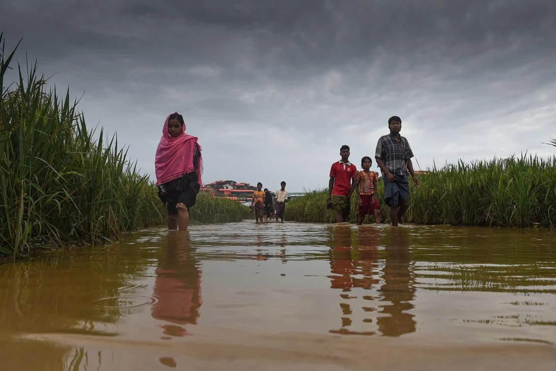 Rohingya refugees walk through water at Thankhali refugee camp in the Bangladeshi district of Ukhia on November 17, 2017. (AFP)