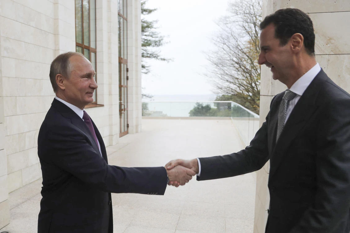 In this Monday, Nov. 20, 2017, photo, Russian President Vladimir Putin, left, shakes hands with Syrian President Bashar Assad in the Bocharov Ruchei residence in the Black Sea resort of Sochi, Russia. (Mikhail Klimentyev, Kremlin Pool Photo via AP)