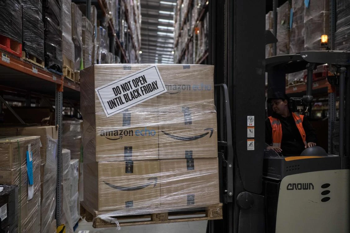 A worker uses a forklift truck to move “Black Friday” labelled goods inside an Amazon.co.uk fulfillment center in Peterborough. Consumer spending — the engine of British economic growth — is being squeezed as inflation rises and wage growth falters, and as shoppers worry about the potential impact of Brexit. (AFP)