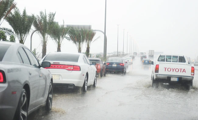 Saudi drivers take a flooded street in Jeddah on Tuesday. (AFP)