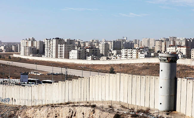 A view shows the Israeli barrier as buildings are seen in Kfar Aqab on the outskirts of Jerusalem, near the West Bank City of Ramallah, in this November 7, 2017 photo. (REUTERS)