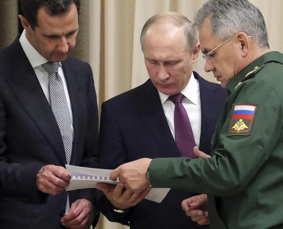 In this Monday, Nov. 20, 2017, photo, Russian President Vladimir Putin, center, and Syrian President Bashar Assad, left, and Russian Defense Minister Sergei Shoigu look at a document during their meeting in the Bocharov Ruchei residence in the Black Sea resort of Sochi, Russia. Putin has met with Assad ahead of a summit between Russia, Turkey and Iran and a new round of Syria peace talks in Geneva, Russian and Syrian state media reported Tuesday. (Mikhail Klimentyev, Kremlin Pool Photo via AP)