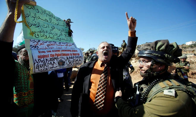 A Palestinian man shouts during a protest against closure of a road by Israeli troops south of the West Bank city of Hebron November 10, 2017. REUTERS/Mussa Qawasma
