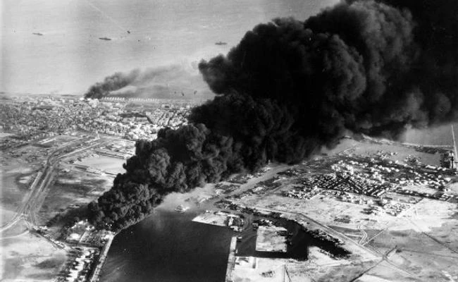 In this photo taken on November 5, 1956, smoke rises from oil tanks beside the Suez Canal that were hit in an air strike during the initial Anglo-French assault on Port Said, Egypt. (Wikimedia Commons)