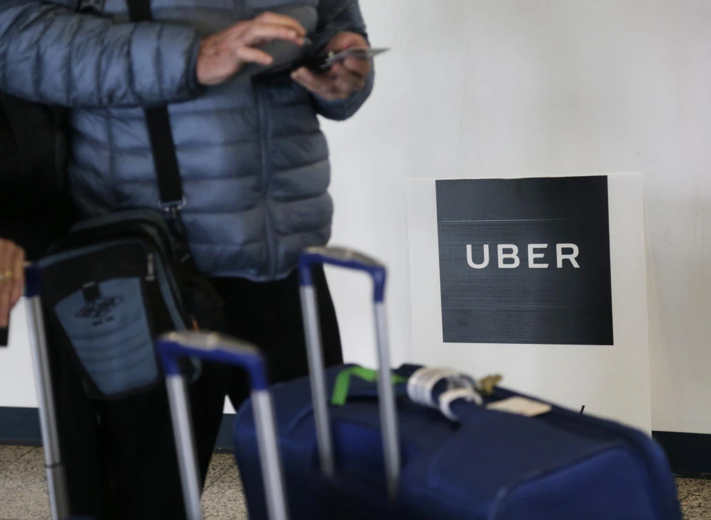 Above, a traveler tries to book a ride with Uber at LaGuardia Airport in New York. Uber was first hacked in October 2016 and discovered the data breach the following month. (AP)