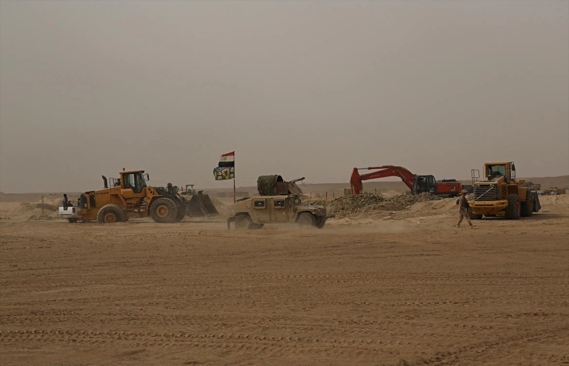 In this Tuesday, Nov. 7, 2017 photo, Iraqi Army armored vehicle patrol while US Marines build a military site in western Anbar, Iraq. The US-led coalition’s newest outpost in the fight against the Daesh group is in a dusty corner of western Iraq just some 20 kilometers from the border with Syria. From here, a couple hundred US marines supported the most recent Iraqi victory against the extremists in the border town of Qaim some 320 kilometers (200 miles) west of Baghdad. (AP Photo/Khalid Mohammed)