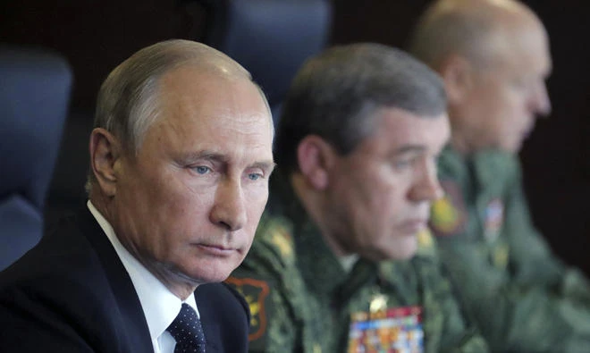 Russian President Vladimir Putin (L) and Chief of the General Staff of Russian Armed Forces Valery Gerasimov (C) watch the Zapad-2017 war games, held by Russian and Belarussian servicemen, at a military training ground in the Leningrad region, Russia, on September 18, 2017.