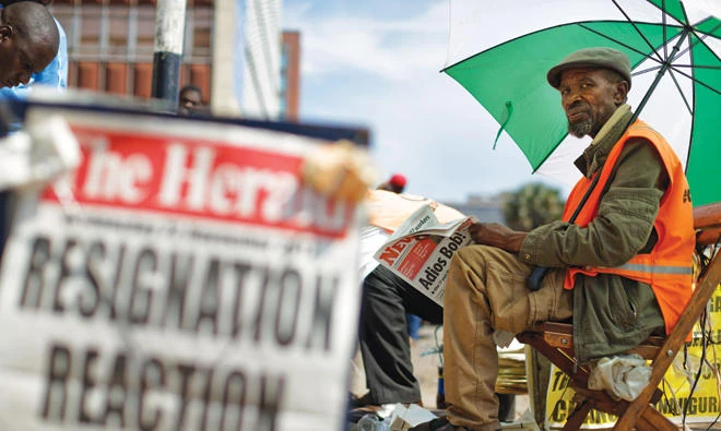 Zimbabweans read morning newspapers a day after President Robert Mugabe resigned. (AP)