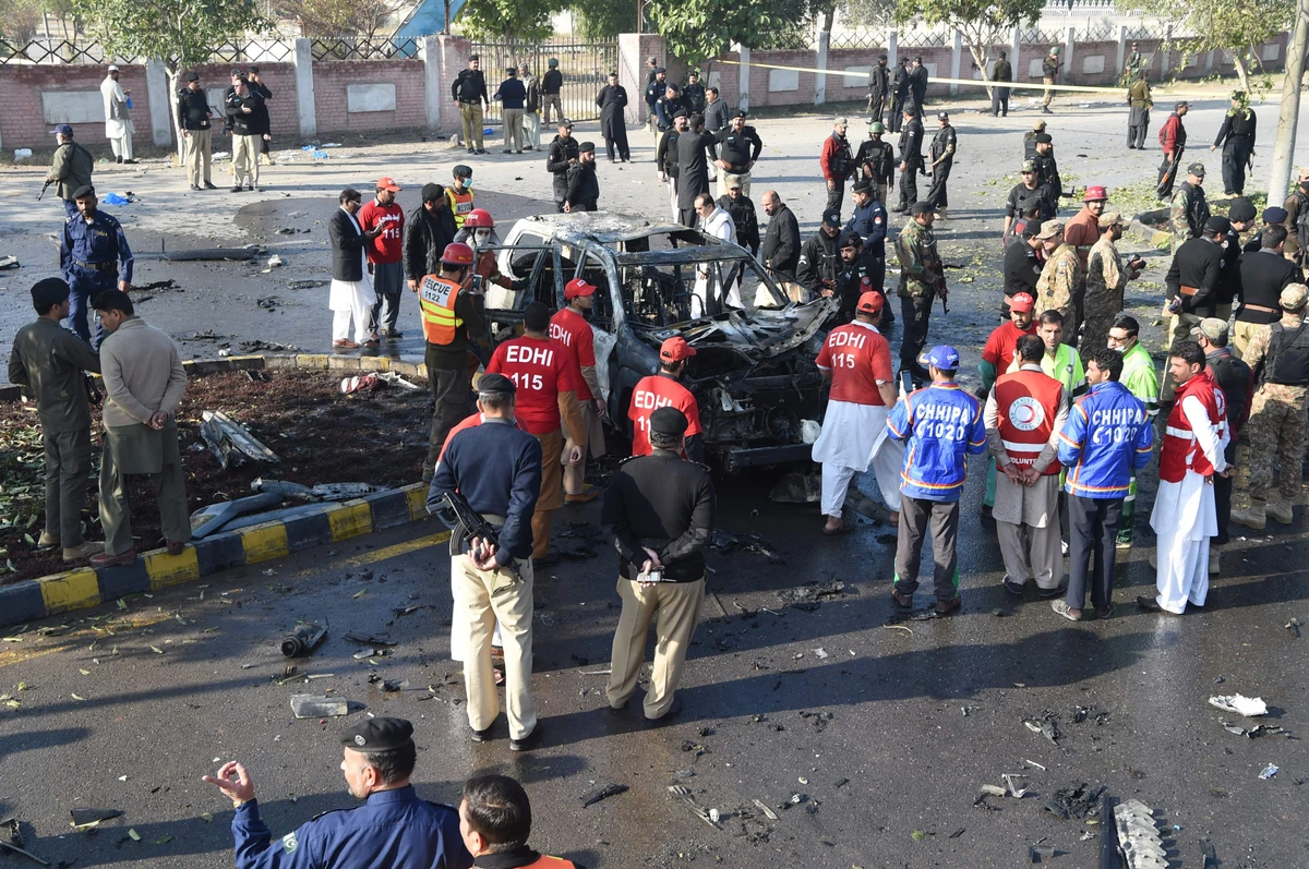 Security personnel inspect a destroyed vehicle at the site of suicide bomb attack that targeted a senior Pakistani police officer in Peshawar on November 24. (AFP)