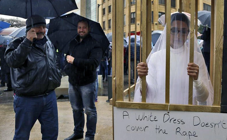 In this file photo, an activist from the Lebanese NGO Abaad stands in a golden cage dressed as a bride while during a protest in front of the government building in downtown Beirut, Lebanon on March 15, 2017. (File photo by AP)