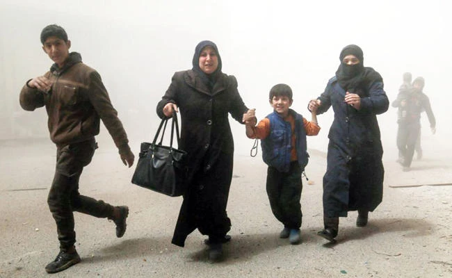 Syrians flee following a reported government airstrike in Hamouria, in the Eastern Ghouta region on the outskirts of the capital Damascus. (AFP/file)