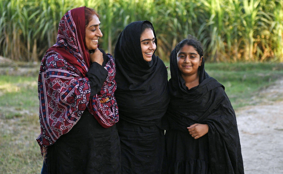 This file photo shows Pakistani woman Mukhtiar Naz, left, known as Waderi Nazo Dharejo, meeting her daughters at her agriculture field in Qazi Ahmed in Sindh province on September 27, 2017. (File photo by AFP)