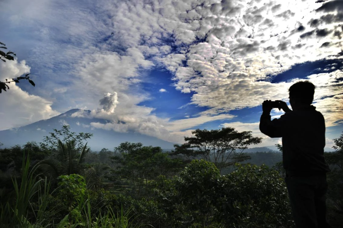 Above, a puff of smoke comes from Mount Agung volcano. About 25,000 people have been unable to return to their homes since September, when Agung showed signs of activity for the first time in more than half a century. (AFP)