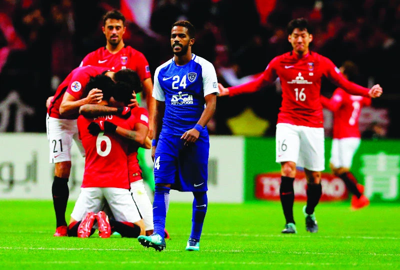 Al-Hilal’s Nawaf Al-Abed looks delighted after the final whistle in Saitama as Urawa Reds players celebrate victory. (AP)