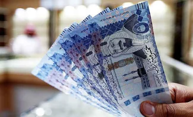 A Saudi money changer displays Saudi Riyal banknotes at a currency exchange shop in Riyadh, Saudi Arabia, in this July 27, 2017 photo. (REUTERS)