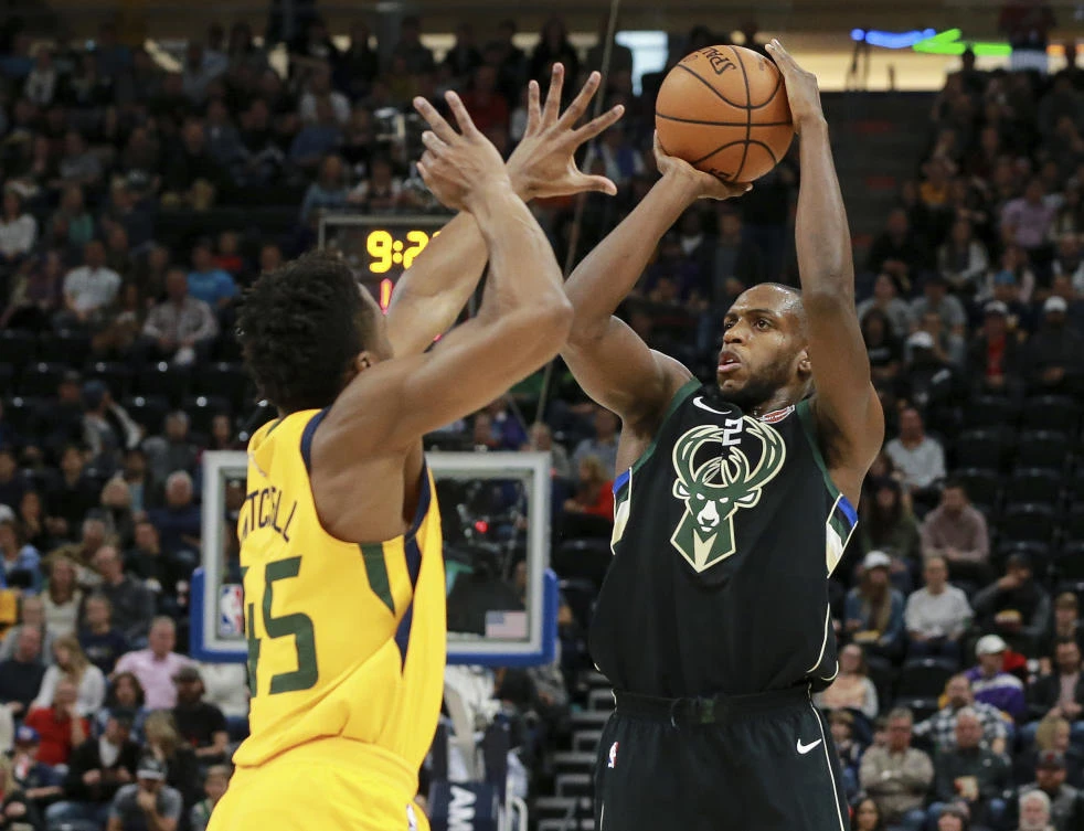 Milwaukee Bucks forward Khris Middleton, right, shoots past Donovan Mitchell in their losing game against Utah Jazz on Saturday evening, November 25. The Jazz have won 16 consecutive games at home over the Bucks. (AP)