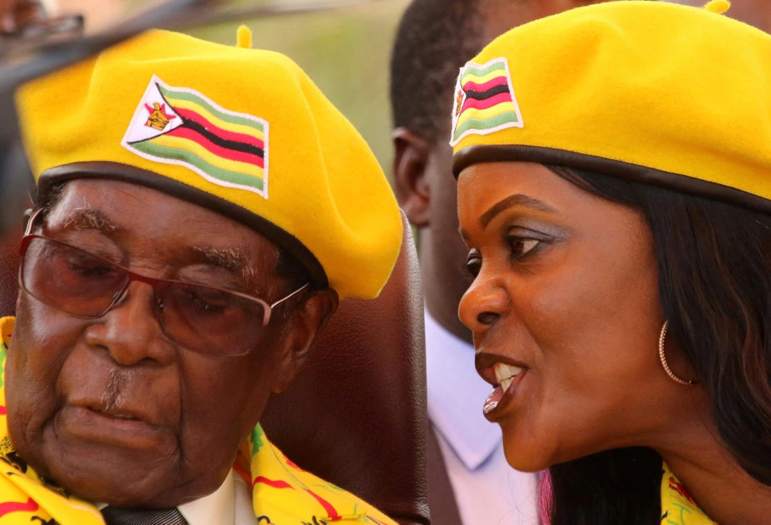 Robert Mugabe, who stepped down as Zimbabwe’s president after 37 years in power, listens to his wife Grace Mugabe at a rally of his ruling ZANU-PF party in Harare. (Reuters)
