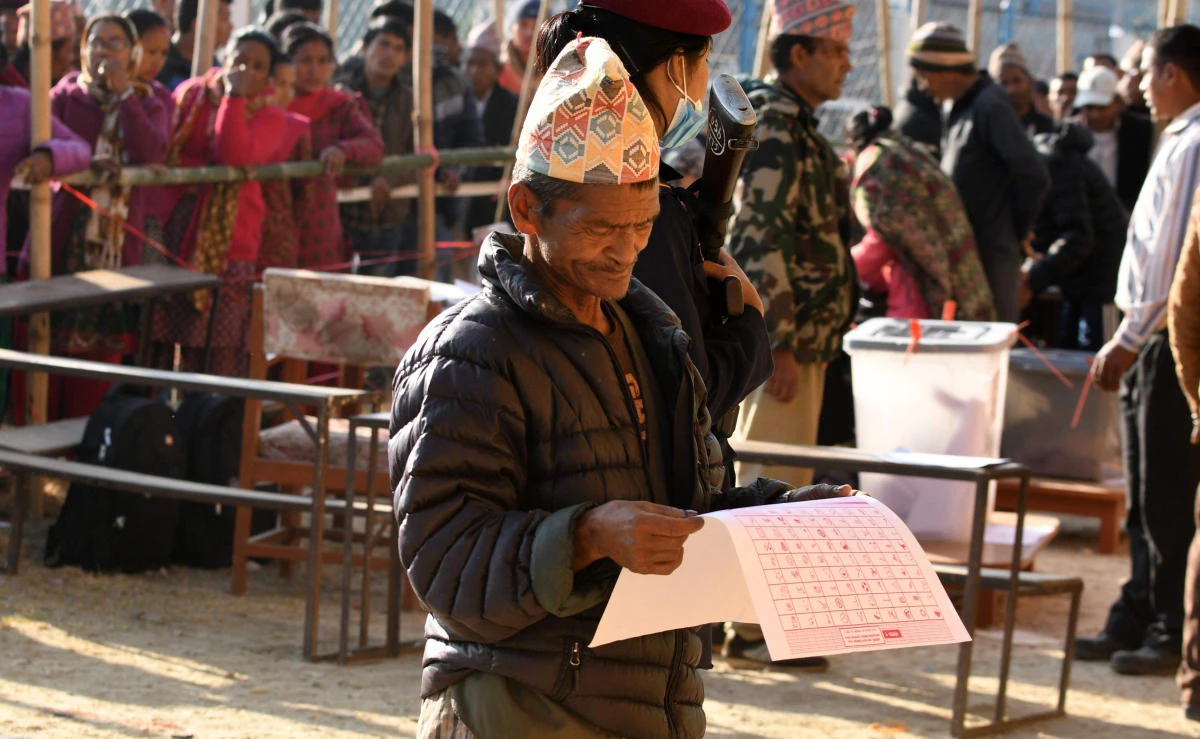 A Nepali voter examines ballot papers before casting his vote at a polling station during the general election at Chautara, Sindhupalchowk district some of 100 kilometers east of Katmandu on November 26, 2017. (AFP)