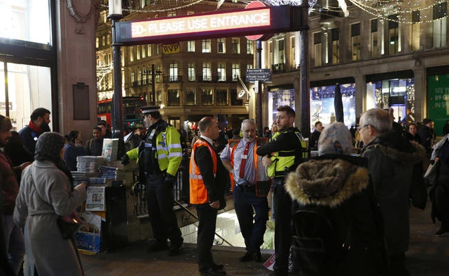 Police officers and Transport for London workers stand at the entrance of Oxford Circus subway station in the west of London after it was reopened Nov. 24, 2017 following a terror warning that turned out to be a false alarm. (AP Photo/Alastair Grant)