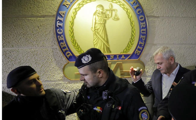 Liviu Dragnea, the powerful leader of Romania's ruling Social Democratic party, makes his way on Nov. 21, 2017 as he leaves the anti-corruption prosecutors' agency in Bucharest, which froze his assets amid a probe into misusing European Union funds and setting up an organized crime group. (AP Photo/Vadim Ghirda)