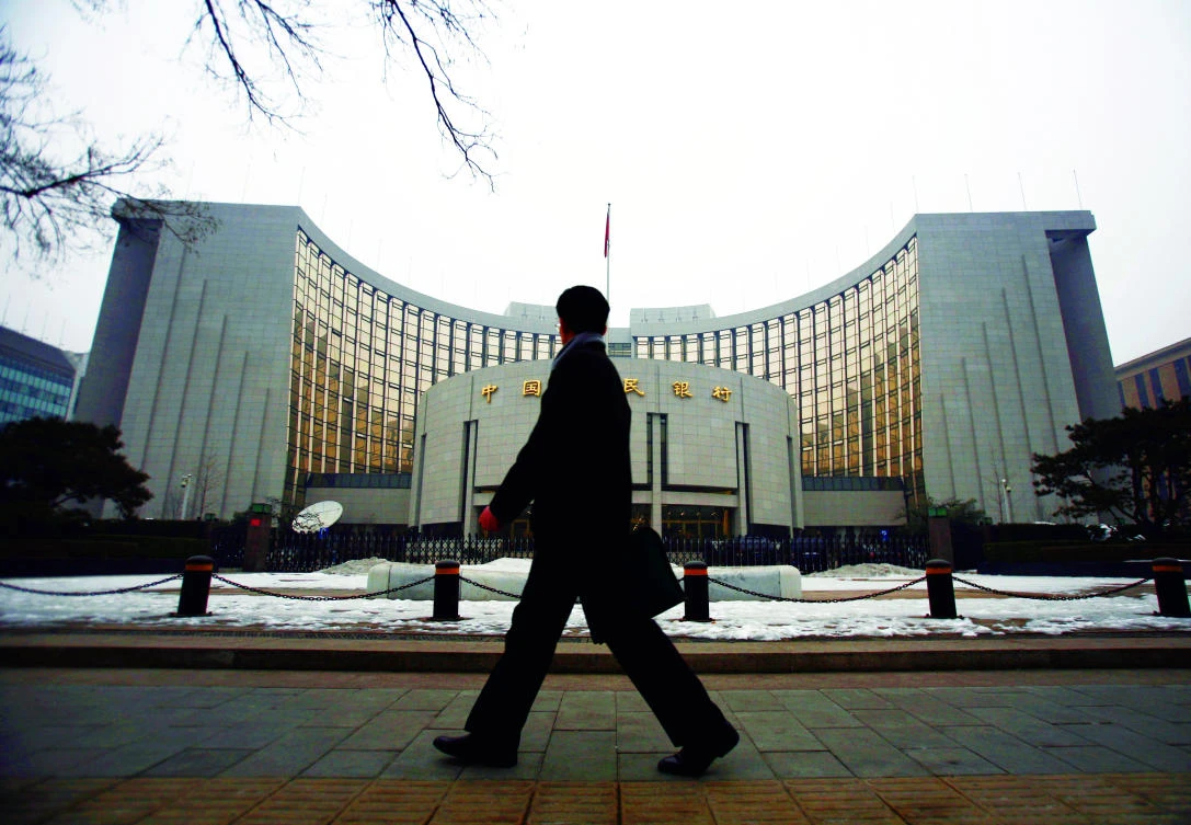 A man walks past the headquarters of the central bank of the People’s Republic of China in Beijing. China is tightening supervision of what the central bank estimates to be a $9 trillion asset management industry. (Reuters)