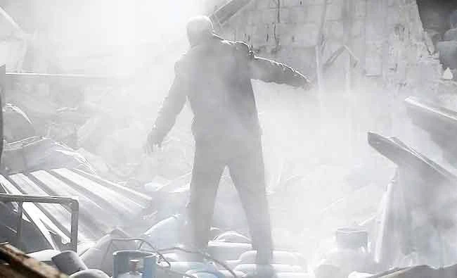 A man stands on the rubble of damaged buildings after an airstrike on the rebel-held town of Mesraba in the eastern Damascus suburb of Ghouta, Syria, on Sunday. (REUTERS)