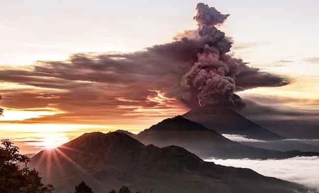 Mount Agung volcano is seen spewing smoke and ash in Bali, Indonesia, on Sunday in this photo obtained from social media. (REUTERS)