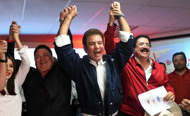 Presidential candidate for the Honduran Opposition Alliance against the Dictatorship, Salvador Nasralla (C) celebrates with Iroshka Elvir de Nasralla (L), Guillermo Valle (2-L) and former president Manuel Zelaya (2-R) after the general election, in Tegucigalpa on November 27, 2017. (AFP / Orlando Sierra)
