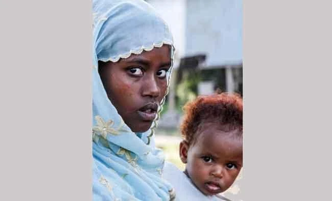 This file photo taken on October 4, 2017 shows an Oromo woman holding a child as she poses at a temporary camp for displaced people outside Adama, Ethiopia. (AFP)
