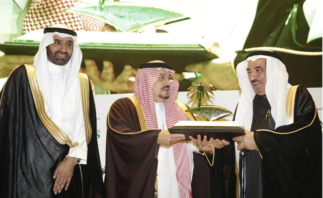 Riyadh Gov. Prince Faisal bin Bandar, center, presents a memento to Saad Al-Moajill, right, at the opening of the Riyadh Economic Forum held in Riyadh on Monday. RCCI President Ahmed Al-Rajihi is on the left. (AN Photo by Iqbal Hossain)