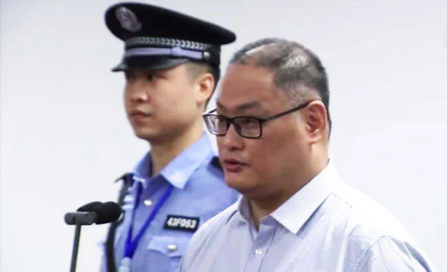 This file video grab from footage on the website of Yueyang Intermediate People's Court taken on September 11, 2017 shows Taiwanese activist Lee Ming-cheh (R) appearing in court in Yueyang in China's central Hunan province. (AFP)