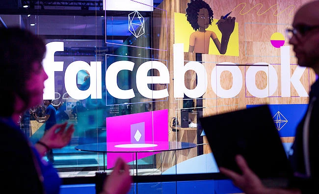 In this April 18, 2017, file photo, conference workers speak in front of a demo booth at Facebook's annual F8 developer conference in San Jose, Calif. (AP)
